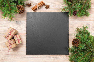 Poster - Slate blackboard on wooden table with christmas decoration. black slate stone on wooden background. copy space. New Year concept