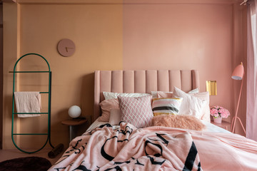 Cozy pink bedroom corner decorated with comfortable pink pillows and fluffy pink blanket setting on two tone painted wall /cozy interior concept / minimal modern design / background advertising