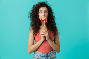 Canvas Print - Portrait of european woman 20s wearing casual clothing eating lollipop, isolated over blue background