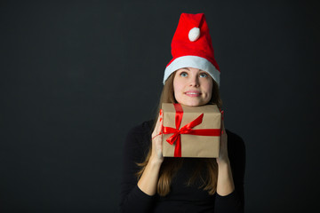 Wall Mural - beautiful young girl with a gift in hand on a black background