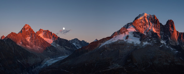 Fototapete - Panorama of the last sunlight on the mountain peaks near Chamonix, France, during moonrise.