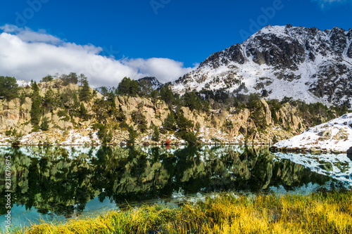 Plakat Pireneje  sniezny-krajobraz-w-parku-narodowym-aiguestortes-katalonia-hiszpania-jezioro-lodowcowe-odzwierciedlajace-otaczajaca-sniezna-gore