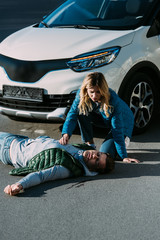 Wall Mural - high angle view of young woman touching victim of motor vehicle collision