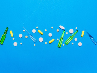 Wall Mural - pharmaceutical medical blue background. Top view of the pills, ampoules, pills. Place for text