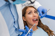 Dentist giving anesthesia to female patient