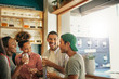 © mavoimages - Diverse young friends talking and drinking together in a bar