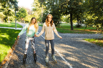 Canvas Print - Two cheerful young girls on on roller skates