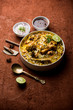 © Arundhati - Delicious spicy chicken biryani in bowl over moody background, it’s a popular Indian and Pakistani food.