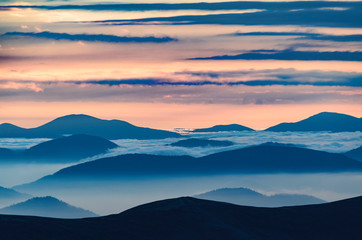 Wall Mural - Amazing sunrise high in the mountains with blue and pink mountain silhouettes