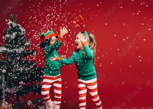 Foto Little girls playing with the artificial snow flakes
