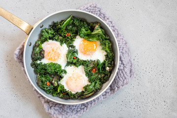 Fried eggs kale green leaves for breakfast