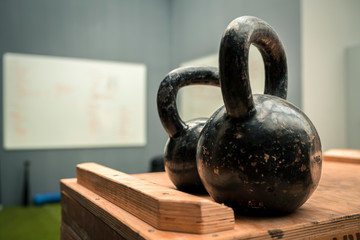 Two heavy balls with handle on a wooden surface in a gymnasium