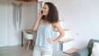 © therabbithole - Young woman talking on mobile phone in stylish apartment.