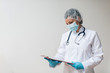 © bnenin - Female doctor in sterile uniform looking at clipboard in the recovery room.