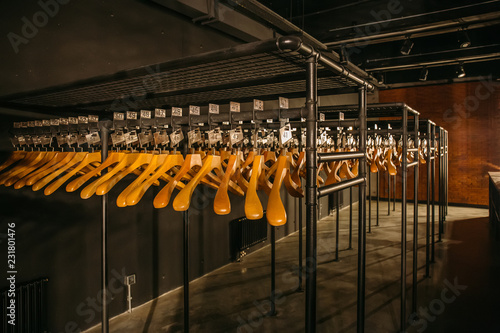 Fotografía Wooden hangers with numbers in dark empty cloakroom or checkroom or wardrobe