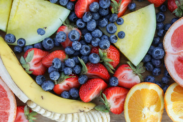 Wall Mural - Fresh fruits on a wooden board at a picnic