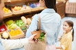 © pressmaster - Close-up of man stealing wallet from bag of young lady walking with daughter in fresh food shop, thief taking purse out of shopping bag
