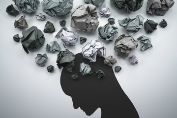 silhouette of troubled person head. concept image of anxiety and negative emotion. waste paper and h