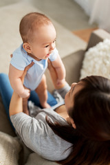 family and motherhood concept - happy young asian mother with little baby son at home