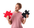 © Pixel-Shot - Young man with pieces of jigsaw puzzle on white background
