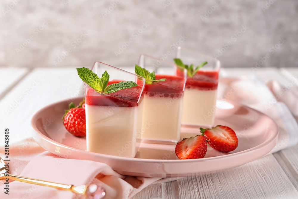 Glasses with tasty strawberry panna cotta on plate