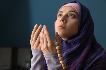 Wall Mural - Young Muslim woman praying at home