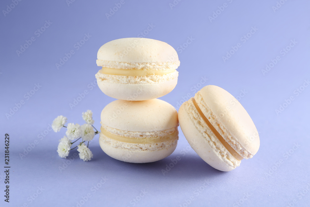 Fresh tasty macaroons on color background