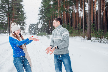 Wall Mural - Cheerful young couple having fun in winter park