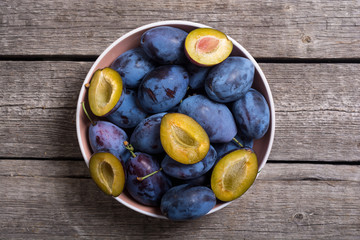 Canvas Print - Fresh plums in bowl on wooden table