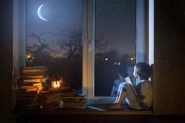  The child sits on the windowsill at night looking at the stars and dreams.