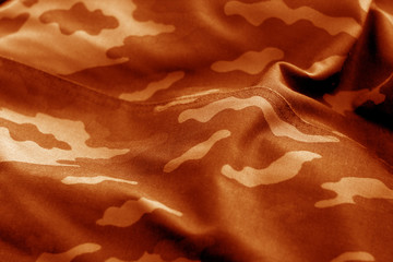 Old camouflage cloth with blur effect in orange tone.