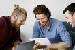 © LUMINA IMAGES - Group of young handsome men looking at digital tablet.