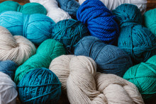 Close Up View Of White, Blue And Green Yarn For Knitting As Backdrop