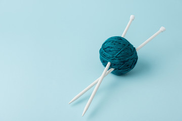 Canvas Print - close up view of yarn ball and knitting needles on blue background