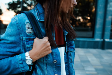 Wall Mural - Close up cropped image of Fashionable young woman in jeans, long jeans jacket and handbag on the city streets. Fashion.Stylish .