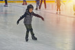 © Daniel CHETRONI - Adorable little boy in winter clothes with protections skating on ice rink