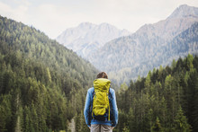 Young Backpacking Man Traveler Enjoying Nature In Alps Mountains. Travel And Active Lifestyle Concept.