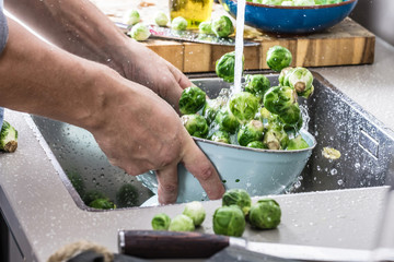 washing raw Brussels sprouts in kitchen sink