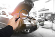Business hand holding magnification with car background