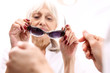 Ochrona oczu przed słońcem, okulary przeciwsłoneczne z filtrem.Starsza kobieta kupuje okulary przeciwsłoneczne
