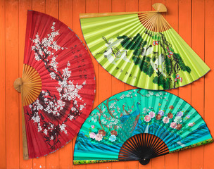 chinese fan on orange wooden background