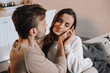 © LIGHTFIELD STUDIOS - smiling tender couple cuddling on couch at home