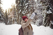 © Northern life - Young woman taking selfie on a background of snow covered winter pine forest. Frosty weather. Big pines. Winter holidays.