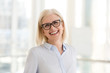 © fizkes - Portrait of smiling middle-aged businesswoman in glasses look in camera making headshot picture, happy mature female employee pose for picture in office, confident woman excited for new opportunities