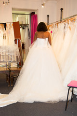 Wall Mural - black Female trying on wedding dress in a shop