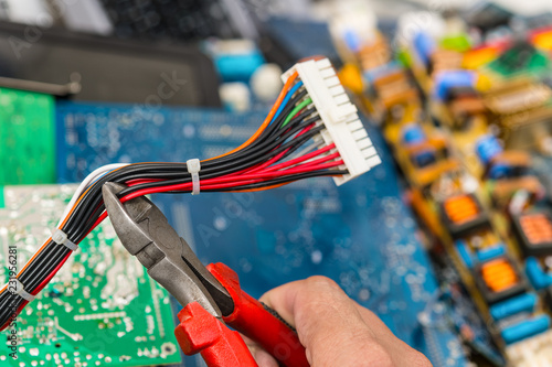Valokuva Disposal of electronic waste with pliers in hand of worker