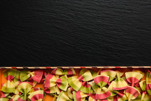 Traditional Italian Flour Product, Colored Pasta In The Form Of Bow On Board, Plate Or Tray Of Black Slate.