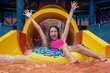Girl in aqua park have fun riding on water slide with inflatable ring