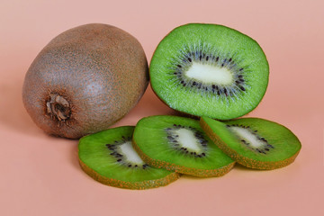 One and half kiwi fruits and three slices, healthy eating concept on an orange background close up