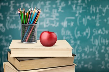 Stack of colorful notebooks, stationery and apple